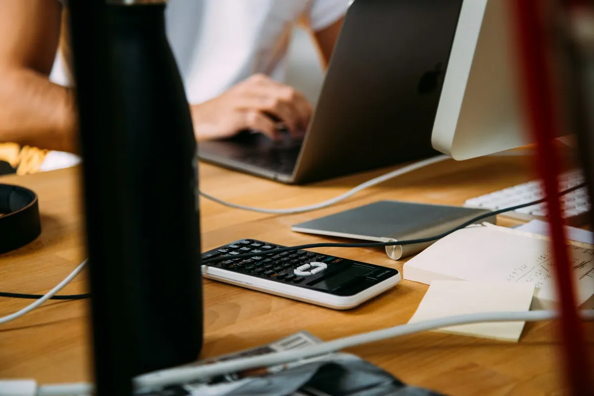 Desk with laptop, calculator, and business notes